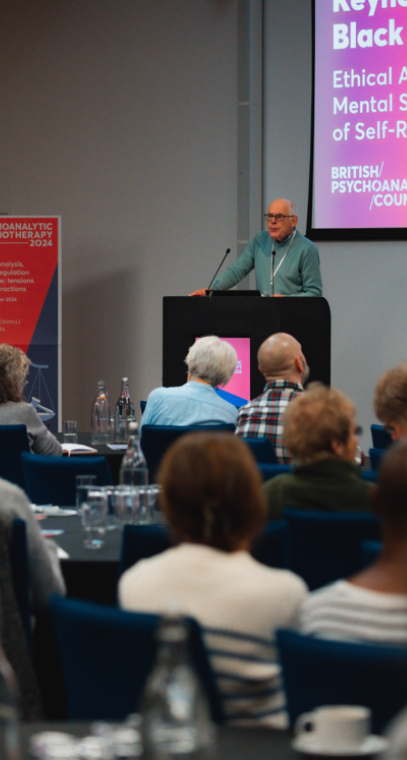 Man presenting to audience at conference.