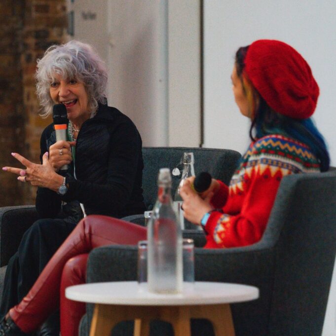 Two women discussing at conference panel.